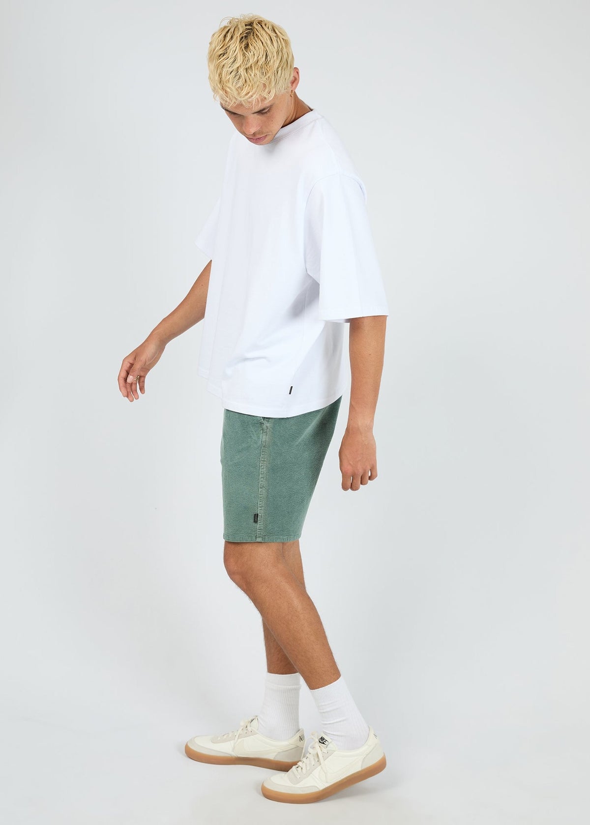 Side view of the Silent Theory Cord Short in bottle green