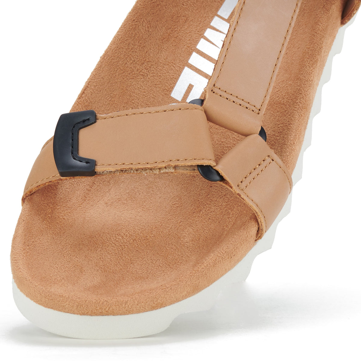 Close view of the tan leather toe strap and suede footbed