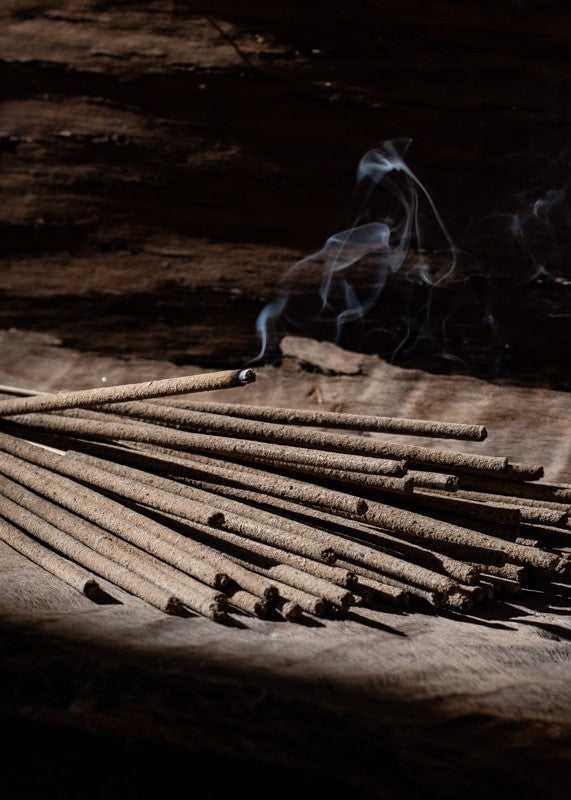 Frankincense incense sticks burning on a wooden board